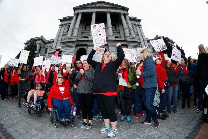 As viewed through a fisheye lens, Stephanie Rolf, a teacher in the Douglas County, Colo., school system, leads a cheer during a teacher rally Thursday, April 26, 2018, in Denver. More than 10,000 teachers in Colorado are expected to demonstrate as part of a burgeoning teacher uprising from the East to the interior West that is demanding more tax dollars be spent in public schools. (AP Photo/David Zalubowski)