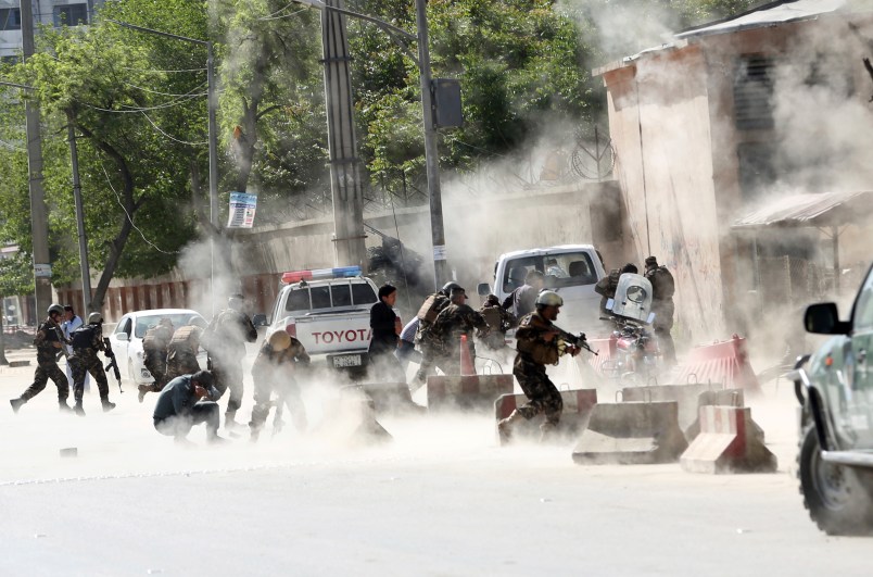 Security forces run from the site of a suicide attack one frame after the second deadly attack in Kabul, Afghanistan, Monday, April 30, 2018.  (AP Photo/Massoud Hossaini)