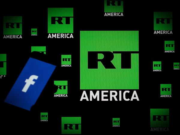 A Facebook logo is seen on a portable device with the logo of Russia Today (RT) news channel in the background in this photo illustration on November 15, 2017. (Photo by Jaap Arriens/NurPhoto)