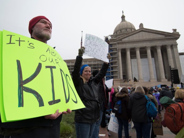 OKLAHOMA CITY, OK - APRIL 2:  Kent Scott, a teacher from Tecumseh, Okla. holds a protest sign at the state capitol in Oklahoma City, Oklahoma on April 2, 2018. Thousands of teachers and supporters are scheduled to rally Monday at the state Capitol as Oklahoma becomes the latest state to be plagued by teacher strife. Teachers are walking off the job after a $6,100 pay raise was rushed through the Legislature and signed into law by Gov. Mary Fallin. (Photo by J Pat Carter/Getty Images)