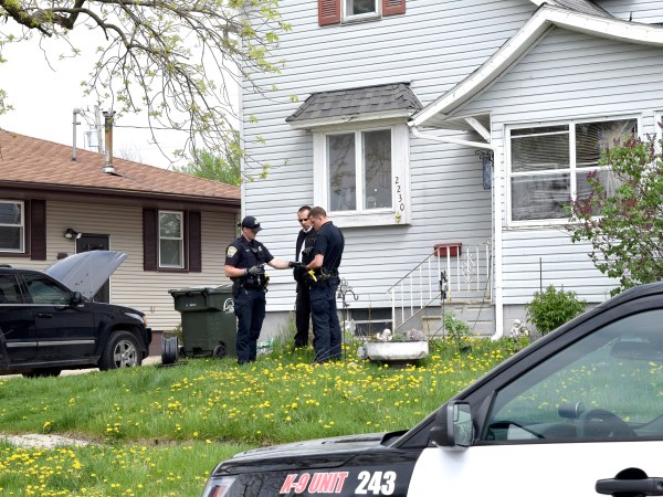 Fort Dodge Police officers Matt Weir, left, Larry Hedlund and Jacob Naatz investigate an accidental shooting, Wednesday, May 9, 2018, in Fort Dodge, Iowa. Richard Remme, of Fort Dodge, told police he was playing with his dog, Balew, on the couch and tossed the dog off his lap. He says when the pit bull-Labrador mix bounded back up, he must have disabled the safety on the gun in his belly band and stepped on the trigger causing the gun to fire and strike Remme in the leg. (Joe Sutter/The Messenger via AP)
