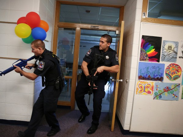Two Cary police officers, including officer Anthony Tangorra, at right, carry blank weapons as they participate in an active shooter exercise with police, emergency workers, teachers and administrators Saturday, Sept. 12, 2015 at Oak Knoll School in Cary, Ill. (Anthony Souffle/Chicago Tribune/TNS)
