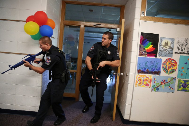 Two Cary police officers, including officer Anthony Tangorra, at right, carry blank weapons as they participate in an active shooter exercise with police, emergency workers, teachers and administrators Saturday, Sept. 12, 2015 at Oak Knoll School in Cary, Ill. (Anthony Souffle/Chicago Tribune/TNS)