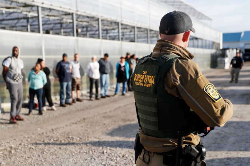 EMBARGOED UNTIL 10AM 6.5.2018Government agents stand guard alongside apprehended suspects during an immigration sting at Corso's Flower and Garden Center, Tuesday, June 5, 2018, in Castalia, Ohio. The operation is one of the largest against employers in recent years on allegations of violating immigration laws. It was expected to cast a net over hundreds of employees at two locations. (AP Photo/John Minchillo)