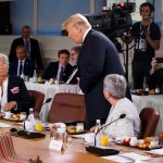 President Donald Trump arrives for a Gender Equality Advisory Council breakfast during the G-7 summit, Saturday, June 9, 2018, in Charlevoix, Canada. From left, German Chancellor Angela Merkel, IMF Managing Director Christine Lagarde, Trump, Christine Whitecross, and Winnie Byanyima. (AP Photo/Evan Vucci)