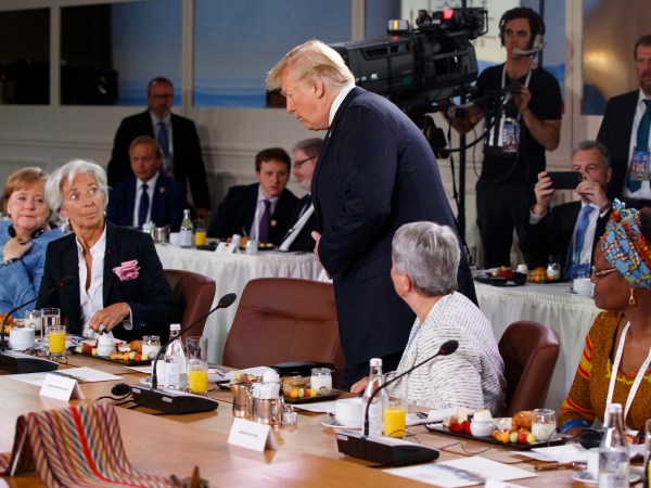 President Donald Trump arrives for a Gender Equality Advisory Council breakfast during the G-7 summit, Saturday, June 9, 2018, in Charlevoix, Canada. From left, German Chancellor Angela Merkel, IMF Managing Director Christine Lagarde, Trump, Christine Whitecross, and Winnie Byanyima. (AP Photo/Evan Vucci)
