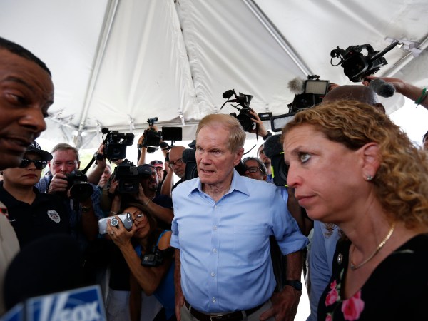 U.S. Sen. Bill Nelson, center and congresswoman Debbie Wasserman Schultz, right, were denied entry by security into the Homestead Temporary Shelter for Unaccompanied Children on Tuesday, June 19, 2018, in Homestead, Fla. (AP Photo/Brynn Anderson)