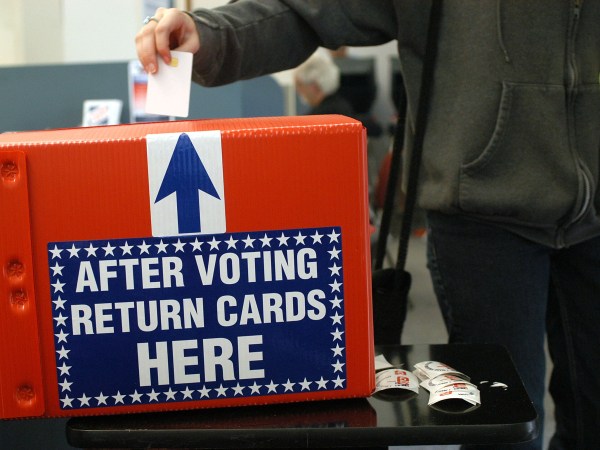 ST PETERSBURG, FLORIDA-OCTOBER 29, 2004:  A woman drops her ballot into the box after early voting in St Petersburg, Fl.  Most people said they waited about 1.5 hours in line to vote today. (Photo by Tim Boyles/Getty Images)