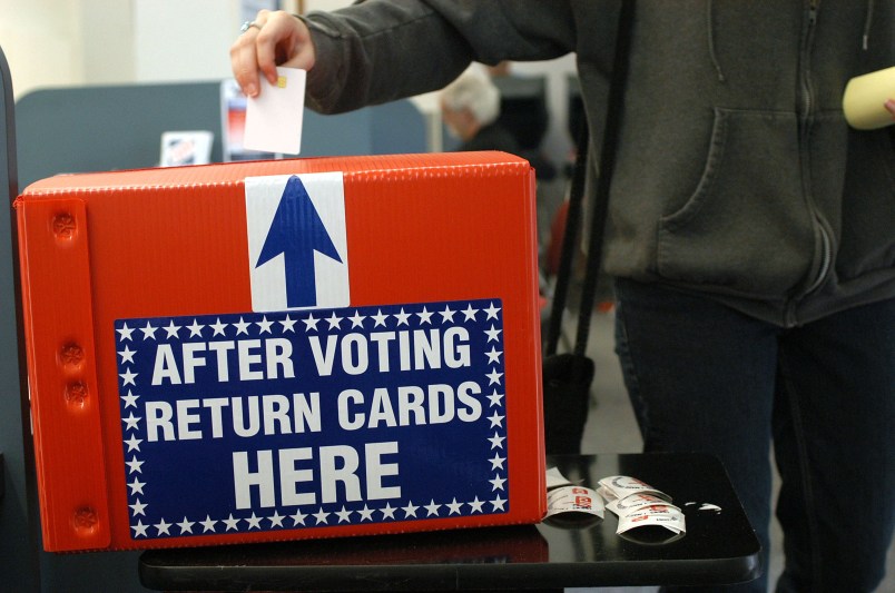 ST PETERSBURG, FLORIDA-OCTOBER 29, 2004:  A woman drops her ballot into the box after early voting in St Petersburg, Fl.  Most people said they waited about 1.5 hours in line to vote today. (Photo by Tim Boyles/Getty Images)