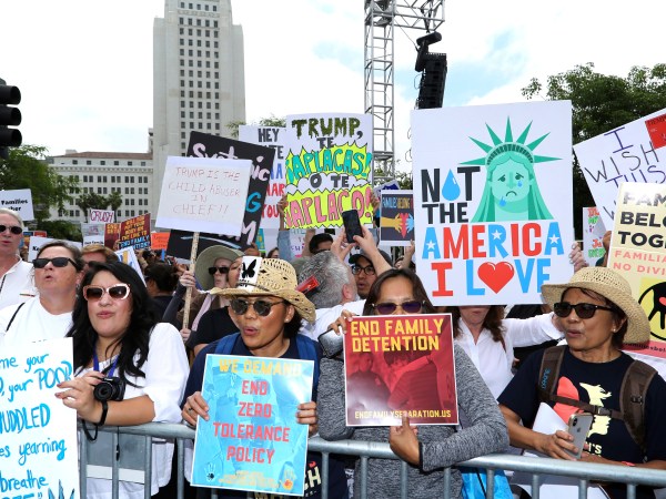 People hold signs as they participate in the "Families Belong Together: Freedom for Immigrants" march on Saturday, June 30, 2018, in Los Angeles. In major cities and tiny towns, marchers gathered across America, moved by accounts of children separated from their parents at the U.S.-Mexico border, in the latest act of mass resistance against President Donald Trump's immigration policies.(Photo by Willy Sanjuan/Invision/AP)