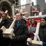 FILE -  In this Dec. 31, 2016 file photo, The Rev. Michael Pfleger, center, Rev. Jesse Jackson, left, and state Sen. Jacqueline Collins, right, led hundreds in a march down Michigan Avenue, carrying crosses for all those killed by Chicago violence in 2016 and to call for an end to violence in Chicago. Protesters planning to shut down a major Chicago interstate on Saturday, July 7, 2018, say they’re trying to increase pressure on public officials to address the gun violence that’s claimed hundreds of lives in some of the city’s poorest neighborhoods. (Ashlee Rezin/Chicago Sun-Times via AP)