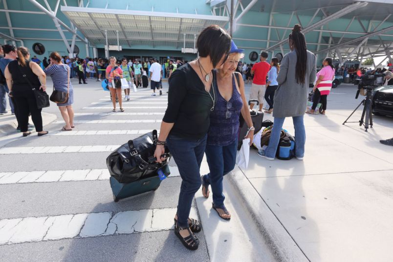 Wanda Collazo escorts her mother Marta Collazo from the arrival area as she departs the Adventure of the Seas after being evacuated from her apartment in Puerto Rico. (Emily Michot/Miami Herald/TNS)