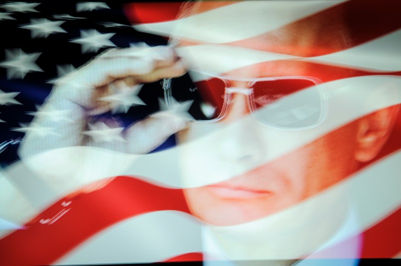 An American flag is seen with a portrait of Russian president Vladimir Putin in this photo illustration on October 31, 2017. Material posted on Facebok and other social media directly and indirectly reached over 126 million Americans between 2015 and 2017 according to a company testimony that will be presented to the US Senate judiciary committe on Tuesday. (Photo by Jaap Arriens/NurPhoto)