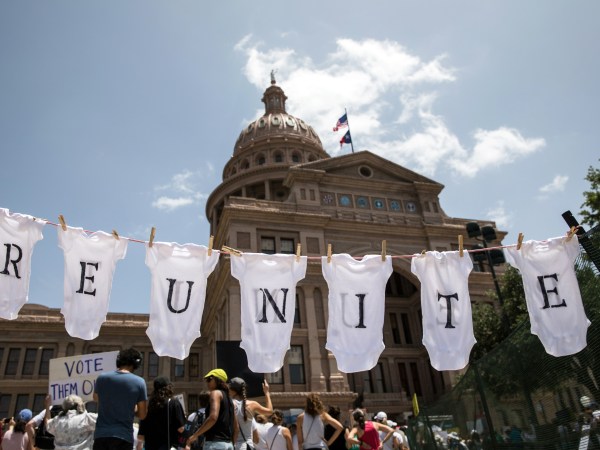 AUSTIN, TX - JUNE 30: A demonstrator uses baby clothes to spell out the word "reunite" during a rally against the Trump administration's immigration policies outside the Texas Capitol in Austin, Texas, on June 30, 2018. Demonstrations are being held in cities across the U.S. Saturday to call for the reunification of separated families and to protest the detention of children and families seeking asylum at the border. (Photo by Tamir Kalifa/Getty Images)