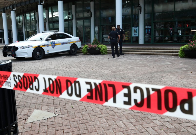 Jacksonville police officers guard an area Monday, Aug. 27, 2018, near the scene of  mass shooting at Jacksonville Landing in Jacksonville, Fla. A gunman opened fire Sunday at an online video game tournament  killing two people and then fatally shooting himself in a rampage that wounded several others. (AP Photo/John Raoux)