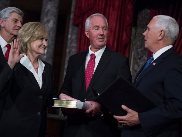 UNITED STATES - APRIL 9: Sen. Cindy Hyde-Smith, R-Miss., participates in her swearing-in ceremony the Capitol's Old Senate Chamber with Vice President Mike Pence, right, and her husband Michael, after being sworn in on the Senate floor on April 9, 2018. Mississippi Gov. Phil Bryant appears at left. (Photo By Tom Williams/CQ Roll Call)