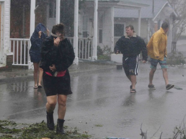 A person shields her face from the wind as Hurricane Florence hit downtown Swansboro N.C.,Friday, Sept. 14, 2018.  (AP Photo/Tom Copeland)