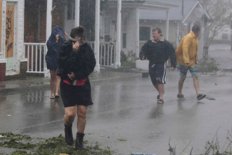 A person shields her face from the wind as Hurricane Florence hit downtown Swansboro N.C.,Friday, Sept. 14, 2018.  (AP Photo/Tom Copeland)