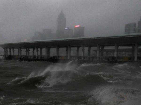 Strong wind caused by Typhoon Mangkhut  is seen on the waterfront of Victoria Habour Hong Kong, Sunday, Sept. 16, 2018. Hong Kong and southern China hunkered down as strong winds and heavy rain from Typhoon Mangkhut lash the densely populated coast. The biggest storm of the year left at least 28 dead from landslides and drownings as it sliced through the northern Philippines. (AP Photo/Vincent Yu)