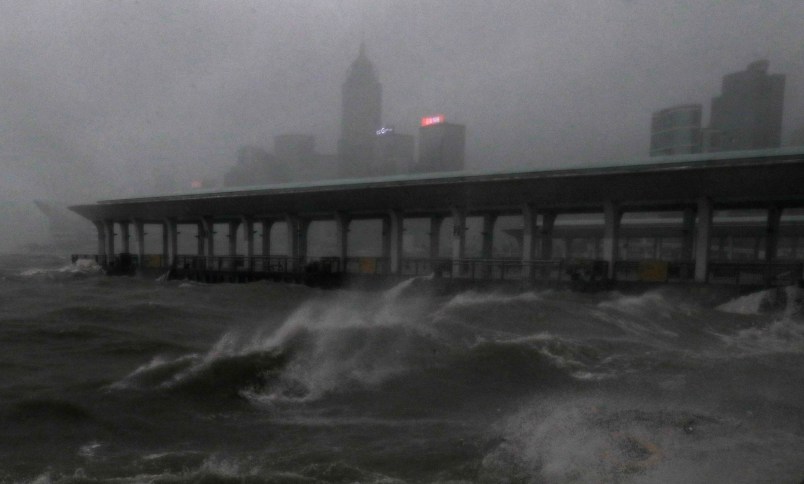 Strong wind caused by Typhoon Mangkhut  is seen on the waterfront of Victoria Habour Hong Kong, Sunday, Sept. 16, 2018. Hong Kong and southern China hunkered down as strong winds and heavy rain from Typhoon Mangkhut lash the densely populated coast. The biggest storm of the year left at least 28 dead from landslides and drownings as it sliced through the northern Philippines. (AP Photo/Vincent Yu)