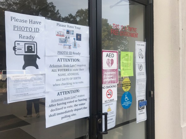 A sign outside the Pulaski County Regional Building in Little Rock, Ark., advises voters on Monday, Oct. 22, 2018, of a state law requiring them to show photo identification before casting a ballot. Early voting began Monday for Arkansas' November 6 midterm election. (AP Photo/Andrew DeMillo)