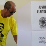 A voter dressed in a shirt with the image of the right-wing presidential candidate Jair Bolsonaro, vote in a polling station in a suburb of Brasilia, Brazil, Sunday, Oct. 28, 2018. Brazil holds today the second round of general elections. (AP Photo/Eraldo Peres)