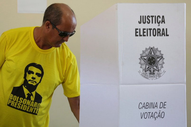 A voter dressed in a shirt with the image of the right-wing presidential candidate Jair Bolsonaro, vote in a polling station in a suburb of Brasilia, Brazil, Sunday, Oct. 28, 2018. Brazil holds today the second round of general elections. (AP Photo/Eraldo Peres)