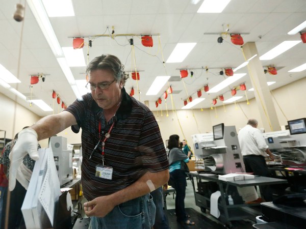 A worker loads ballots into machines at the Broward County Supervisor of Elections office during a recount on Tuesday, Nov. 13, 2018, in Lauderhill, Fla. (AP Photo/Brynn Anderson)