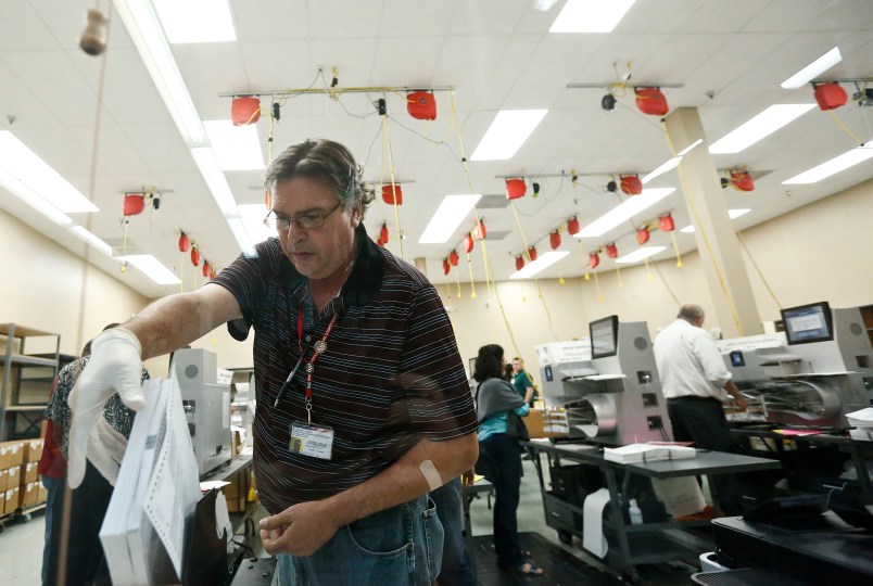 A worker loads ballots into machines at the Broward County Supervisor of Elections office during a recount on Tuesday, Nov. 13, 2018, in Lauderhill, Fla. (AP Photo/Brynn Anderson)