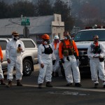 First responders look on as the motorcade of President Donald Trump visits a neighborhood impacted by the wildfires, Saturday, Nov. 17, 2018, in Paradise, Calif. (AP Photo/Evan Vucci)