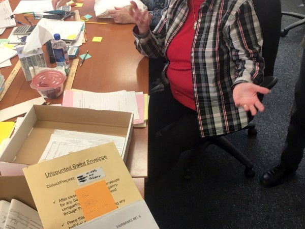 This Nov. 23, 2018 photo shows Alaska State Review Board ballot examiner Stuart Sliter reacting when a loose ballot from a tied state House race is found without an envelope in Juneau, Alaska. Officials are investigating the origin of the ballot and will decide by Friday, Nov. 30, 2018, whether to count it during a recount of the Fairbanks House District 1 race. (James Brooks/Anchorage Daily News via AP)