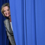 Senator Cindy Hyde-Smith peaks out from behind a curtain before a rally with US President Donald Trump at  Landers Center √ê Arena in Southaven, Mississippi, on October 2, 2018. (Photo by MANDEL NGAN / AFP)        (Photo credit should read MANDEL NGAN/AFP/Getty Images)