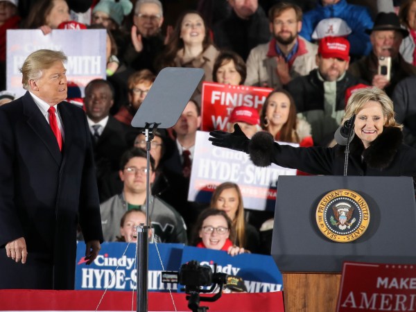 TUPELO, MS - NOVEMBER 26: (L-R) President Donald Trump looks on as Republican candidate for U.S. Senate Cindy Hyde-Smith thanks him during a rally at the Tupelo Regional Airport, November 26, 2018 in Tupelo, Mississippi. President Trump is holding two rallies on Monday in Mississippi, in support of Republican candidate for U.S. Senate Cindy Hyde-Smith. Hyde-Smith faces off against Democratic candidate Mike Espy in a runoff election on Tuesday. (Photo by Drew Angerer/Getty Images)