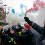 Ambulance workers hold flares outside the National Assembly in Paris, Monday, Dec. 3, 2018. Ambulance workers took to the streets and gathered close to the National Assembly in downtown Paris to complain about changes to working conditions as French Prime Minister Edouard Philippe is holding crisis talks with representatives of major political parties in the wake of violent anti-government protests that have rocked Paris. (AP Photo/Michel Euler)