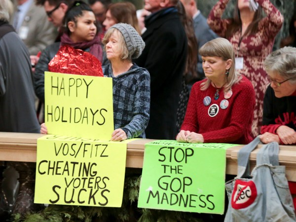 Protesters Peppi Elder, left, and Christine Taylor during the lighting of the 2018 State Capitol Christmas Tree in the Wisconsin State Capitol Rotunda. The Senate and Assembly are set to send dozens of changes in state law to Gov. Scott Walker’s desk Tuesday Dec. 4, 2018 at the Capitol in Madison. (AP Photo/Wisconsin State Journal, Steve Apps)