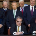 Acting EPA Administrator Andrew Wheeler, seated left, signs an order withdrawing federal protections for countless waterways and wetlands, as Assistant Secretary of the Army for Civil Works Rickey "RD" James, seated right, looks on, at EPA headquarters in Washington, Tuesday, Dec. 11, 2018. Look on behind are Senate Agriculture Committe Chairman Pat Ross, R-Kansas, left, and Secretary of the Interior Ryan Zinke, second from right.   (AP Photo/Cliff Owen)