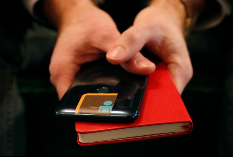 HOLD FOR STORY BY RAPHAEL SATTER - John Scott-Railton, a senior researcher at Citizen Lab, holds his cell phone, whose camera is blocked by an adhesive sticker, as he psoes for a photograph, Thursday, Jan. 17, 2019, in New York. Citizen Lab research includes investigating digital espionage, documenting Internet filtering and other technologies and practices that impact freedom of expression online. But recently Scott-Railton believes he has become a target, hence the extra protection. (AP Photo/Kathy Willens)