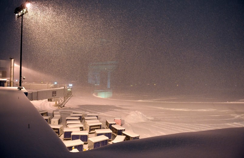 Airline baggage carts sit on the tarmac as crews prepare to move snow at the Albany International Airport in Colonie, N.Y., Sunday, Jan. 20, 2019. (AP Photo/Hans Pennink)