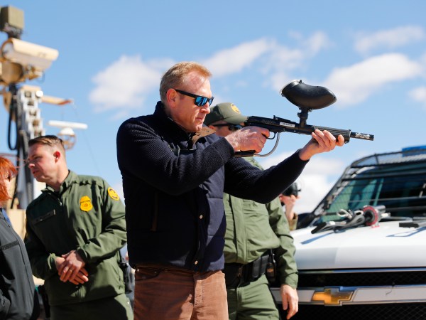 Acting Secretary of Defense Patrick Shanahan, center, fires a modified painted ball gun during a tour of the US-Mexico border at Santa Teresa Station in Sunland Park, N.M., Saturday, Feb. 23, 2019. (AP Photo/Pablo Martinez Monsivais)