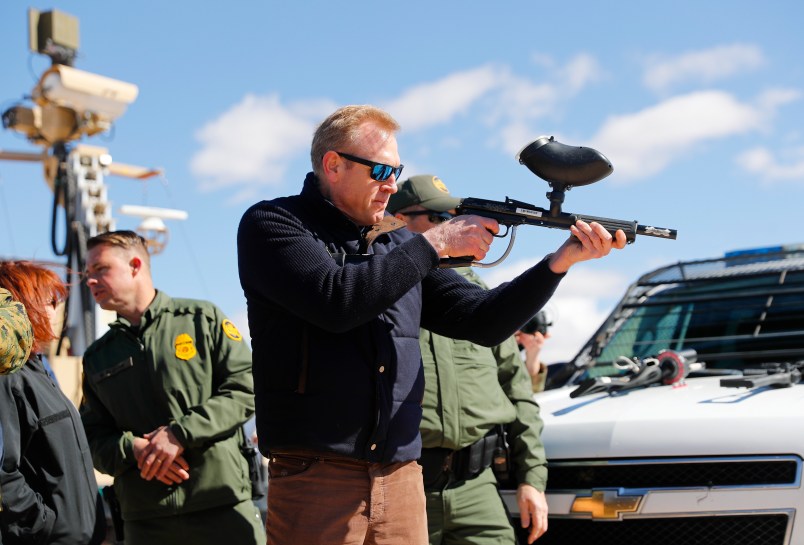 Acting Secretary of Defense Patrick Shanahan, center, fires a modified painted ball gun during a tour of the US-Mexico border at Santa Teresa Station in Sunland Park, N.M., Saturday, Feb. 23, 2019. (AP Photo/Pablo Martinez Monsivais)