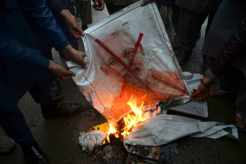 Pakistani protesters burn a poster of Indian Prime Minister Narendra Modi during an anti-Indian rally in Peshawar, Pakistan, Tuesday, Feb. 26, 2019. Pakistan said India launched an airstrike on its territory early Tuesday that caused no casualties, while India said it targeted a terrorist training camp in a pre-emptive strike that killed a "very large number" of militants. (AP Photo/Muhammad Sajjad)