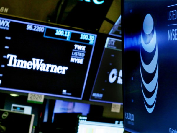 The logos for Time Warner and AT&T appear above alternate trading posts on the floor of the New York Stock Exchange, Wednesday, June 13, 2018. A federal judge has approved the $85 billion mega-merger of AT&T and Time Warner, potentially ushering in a wave of media consolidation while shaping how much consumers pay for streaming TV and movies. (AP Photo/Richard Drew)