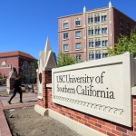 FILE - This Tuesday, March 12, 2019 file photo shows the University Village area of the University of Southern California in Los Angeles. The university says a review of students possibly connected to a college admissions bribery scandal could lead to expulsions. The university said in a statement Monday, March 18, 2019, it has placed holds on the accounts of those students, which prevents them from registering for classes or acquiring transcripts while their cases are under review. (AP Photo/Reed Saxon,File)