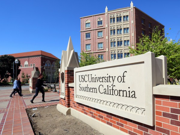 FILE - This Tuesday, March 12, 2019 file photo shows the University Village area of the University of Southern California in Los Angeles. The university says a review of students possibly connected to a college admissions bribery scandal could lead to expulsions. The university said in a statement Monday, March 18, 2019, it has placed holds on the accounts of those students, which prevents them from registering for classes or acquiring transcripts while their cases are under review. (AP Photo/Reed Saxon,File)