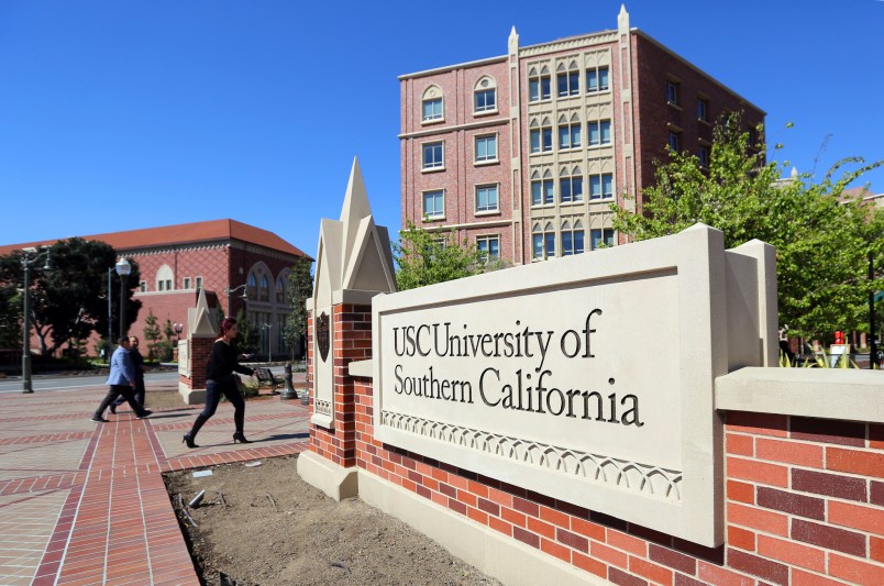 FILE - This Tuesday, March 12, 2019 file photo shows the University Village area of the University of Southern California in Los Angeles. The university says a review of students possibly connected to a college admissions bribery scandal could lead to expulsions. The university said in a statement Monday, March 18, 2019, it has placed holds on the accounts of those students, which prevents them from registering for classes or acquiring transcripts while their cases are under review. (AP Photo/Reed Saxon,File)