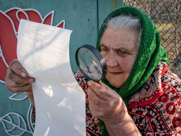 An elderly woman examines her ballot voting at home during the president elections in Mariinka, near a contact line not far from Donetsk, eastern Ukraine, Sunday, March 31, 2019. Ukrainians choose from among 39 candidates for a president they hope can guide the country of more than 42 million out of troubles including endemic corruption, a seemingly intractable conflict with Russia-backed separatists in the country's east and a struggling economy. (AP Photo/Evgeniy Maloletka)