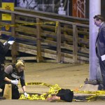 Police work near the scene where authorities say seven people were shot, at least one fatally, in Baltimore on Sunday, April 28, 2019. (AP Photo/Steve Ruark)