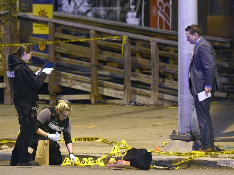 Police work near the scene where authorities say seven people were shot, at least one fatally, in Baltimore on Sunday, April 28, 2019. (AP Photo/Steve Ruark)