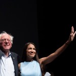 WICHITA, KA - JULY 20: James Thompson, Senator Bernie Sanders and Alexandria Ocasio-Cortez,  wave to the crowd at the end of a campaign rally in Wichita, Kansas on July 20, 2018.  (Photo by J Pat Carter for the Washington Post)