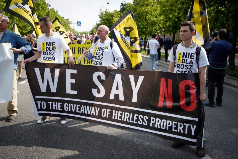 People hold a banner during a protest against the JUST act in Warsaw, Poland on May 11, 2019. Several thousand people gathered in front of the Prime Minister's office and marched to the US embassy to protest the Justice for Uncompensated Survivors Today (JUST) act 447 which requires the US State Department to report on progress made by 47 countries on compensation of assests seized during WWII for Holocaust survivors. Poland is the only European country that has not yet passed any laws to regulate compensation for rightful owners of seized properties. (Photo by Jaap Arriens/NurPhoto)
